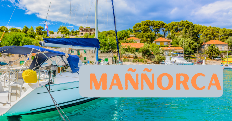 A sailboat docked in a picturesque harbor with clear turquoise waters, lush green trees, and charming buildings in the background. The text "MAÑÑORCA" is prominently displayed over the image.